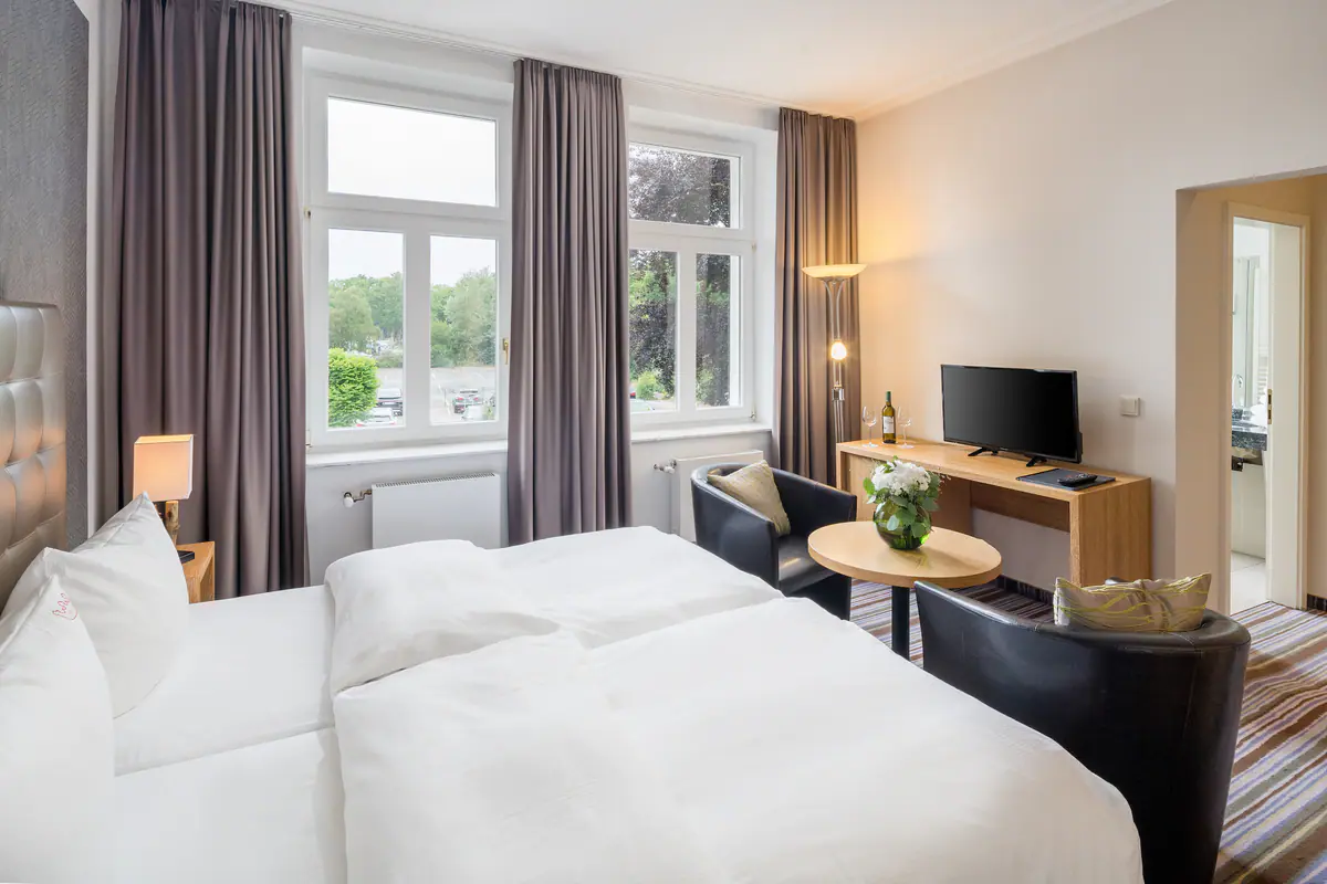 Doppelzimmer mit Schreibtisch und Fensterfront
