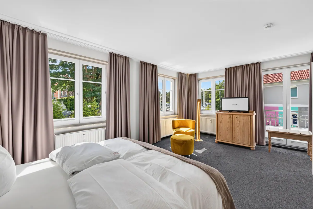 Schlafzimmer mit gelben Hockern und Balkontür