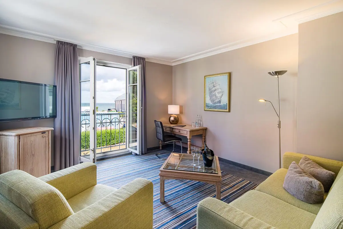 Wohnbereich mit grünen Sofas und Balkon