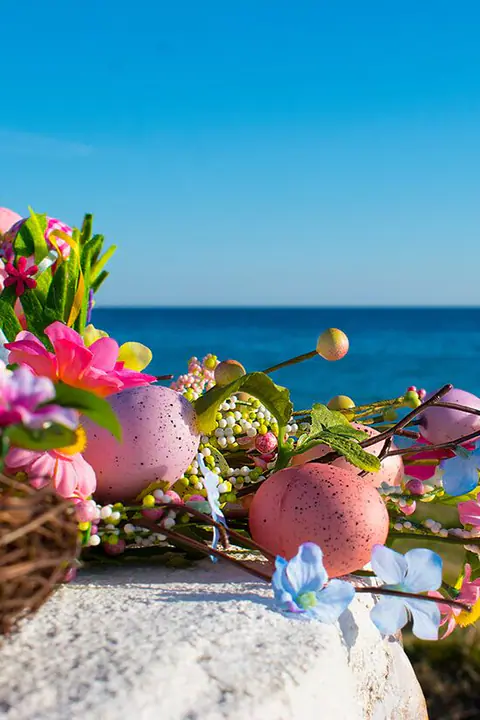 Ostereier und Frühlingsblumen vor dem Meer
