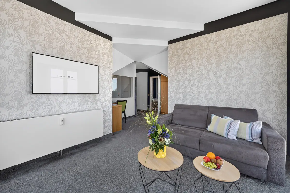 Wohnbereich der Turmsuite mit grauer Couch und Galerie